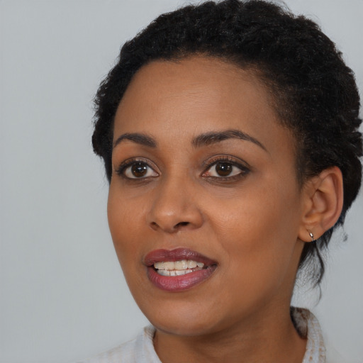 Joyful black young-adult female with medium  black hair and brown eyes