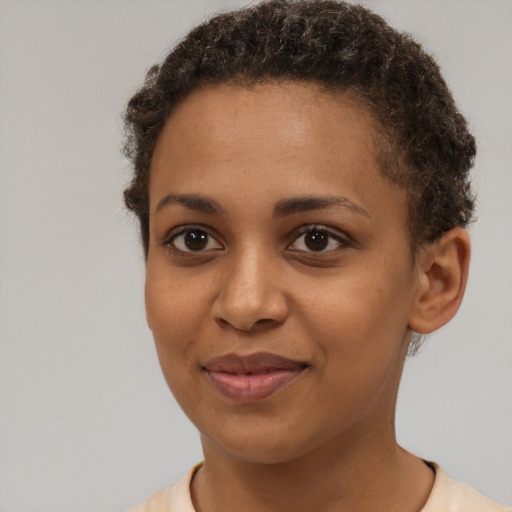 Joyful black young-adult female with short  brown hair and brown eyes