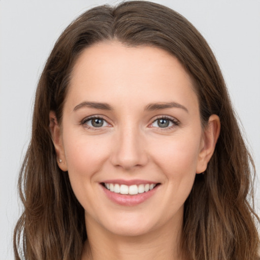 Joyful white young-adult female with long  brown hair and grey eyes