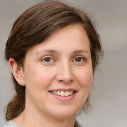 Joyful white adult female with medium  brown hair and grey eyes