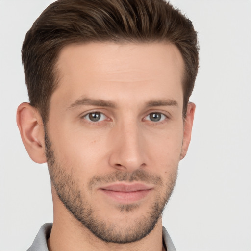 Joyful white young-adult male with short  brown hair and grey eyes