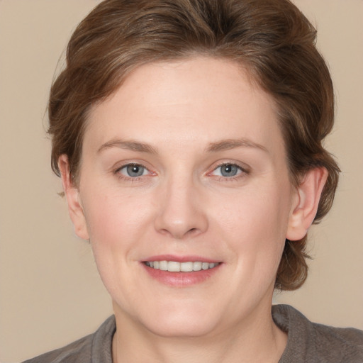 Joyful white young-adult female with medium  brown hair and grey eyes