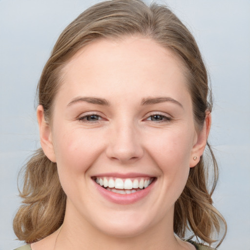 Joyful white young-adult female with medium  brown hair and grey eyes