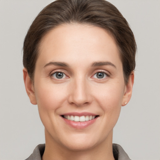 Joyful white young-adult female with short  brown hair and grey eyes