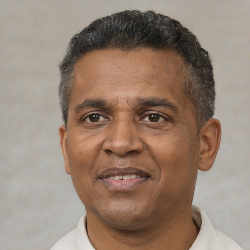 Joyful black adult male with short  black hair and brown eyes