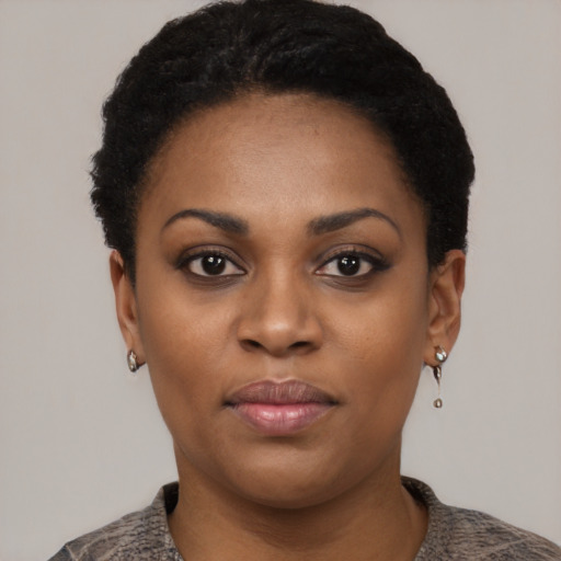 Joyful black young-adult female with short  black hair and brown eyes