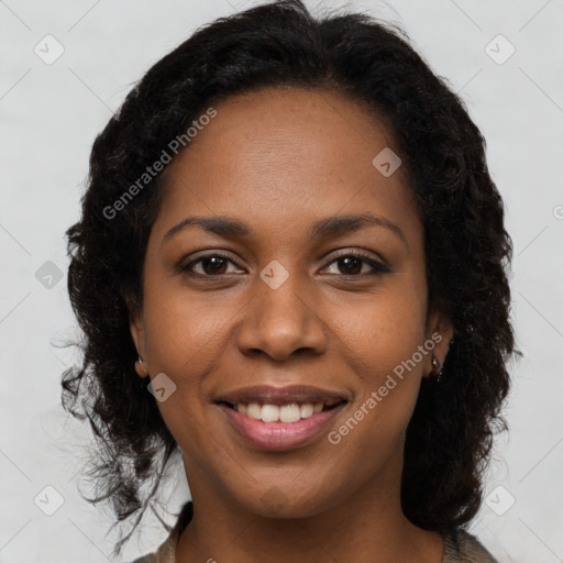 Joyful black young-adult female with long  brown hair and brown eyes