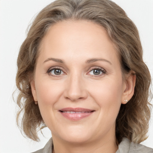 Joyful white adult female with medium  brown hair and grey eyes