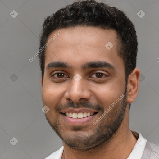 Joyful black young-adult male with short  brown hair and brown eyes