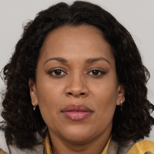 Joyful black adult female with medium  brown hair and brown eyes