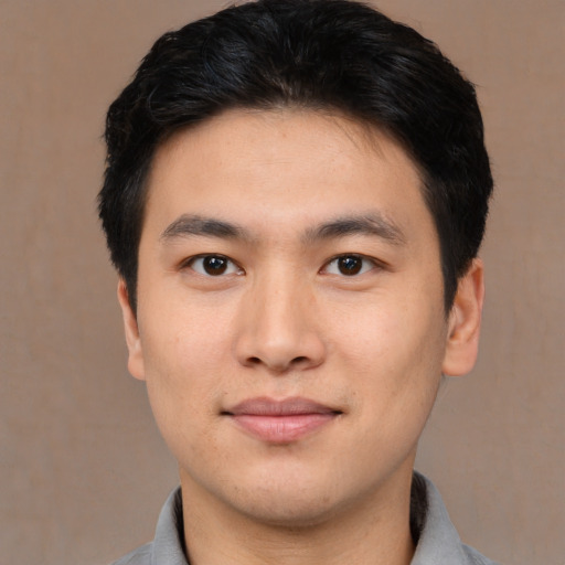 Joyful asian young-adult male with short  brown hair and brown eyes