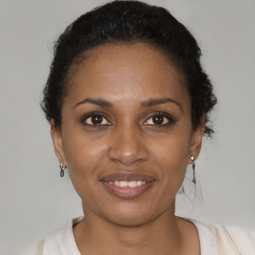 Joyful black young-adult female with short  brown hair and brown eyes