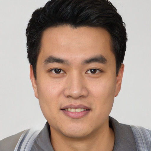 Joyful asian young-adult male with short  black hair and brown eyes