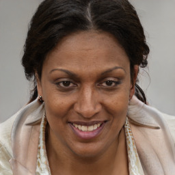 Joyful black adult female with medium  brown hair and brown eyes