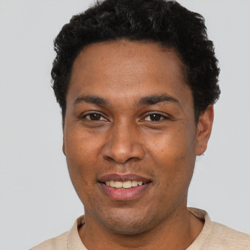 Joyful black young-adult male with short  black hair and brown eyes