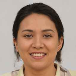 Joyful latino young-adult female with medium  brown hair and brown eyes