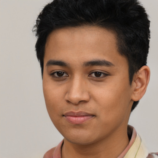Joyful latino young-adult male with short  black hair and brown eyes
