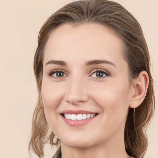 Joyful white young-adult female with medium  brown hair and grey eyes