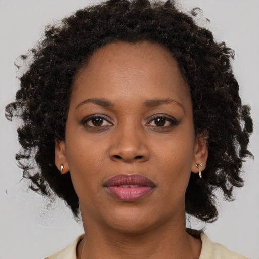 Joyful black adult female with medium  brown hair and brown eyes