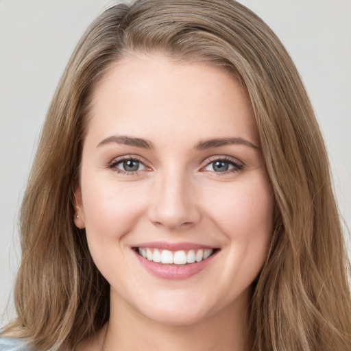 Joyful white young-adult female with long  brown hair and green eyes