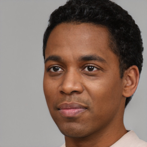 Joyful black young-adult male with short  black hair and brown eyes