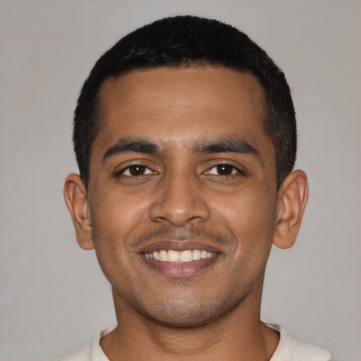Joyful black young-adult male with short  black hair and brown eyes