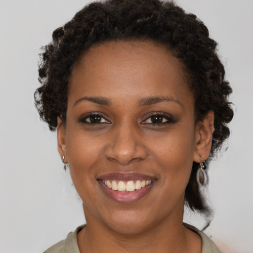 Joyful black young-adult female with short  brown hair and brown eyes