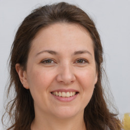 Joyful white adult female with long  brown hair and brown eyes