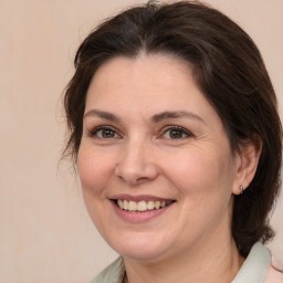 Joyful white adult female with medium  brown hair and brown eyes