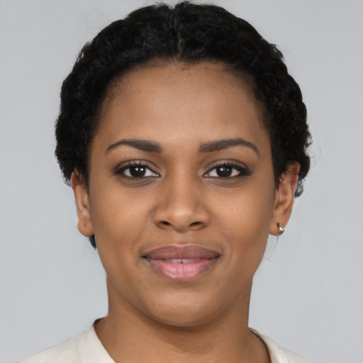 Joyful black young-adult female with short  black hair and brown eyes