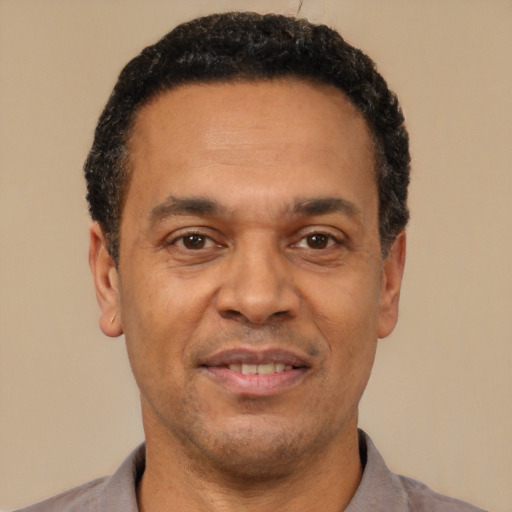 Joyful latino adult male with short  black hair and brown eyes