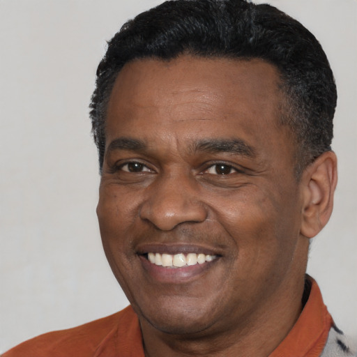 Joyful black adult male with short  black hair and brown eyes