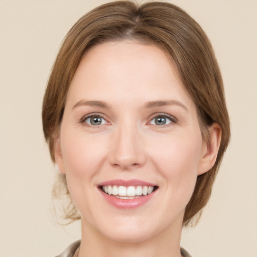 Joyful white young-adult female with medium  brown hair and green eyes