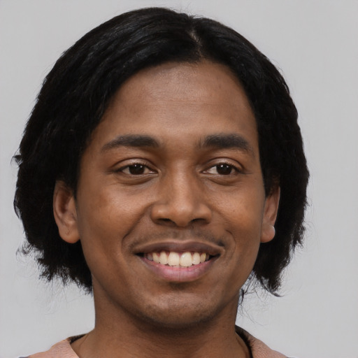 Joyful black young-adult male with medium  black hair and brown eyes