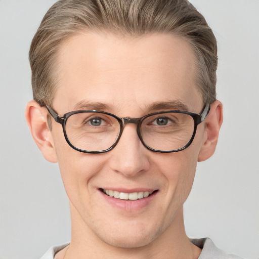 Joyful white adult male with short  brown hair and blue eyes