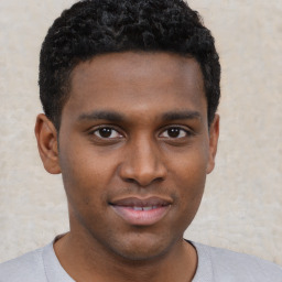 Joyful black young-adult male with short  brown hair and brown eyes