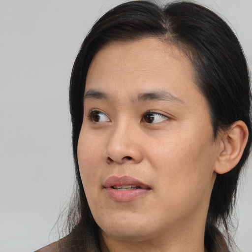 Joyful asian young-adult female with long  black hair and brown eyes