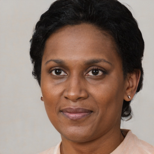 Joyful black adult female with short  black hair and brown eyes