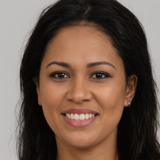 Joyful latino young-adult female with long  brown hair and brown eyes