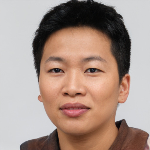 Joyful asian young-adult male with short  black hair and brown eyes