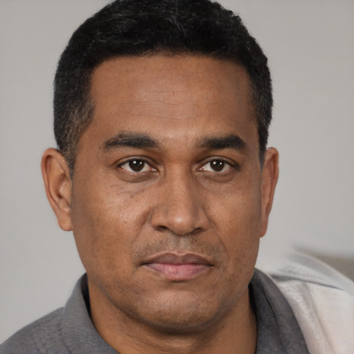 Joyful latino adult male with short  black hair and brown eyes