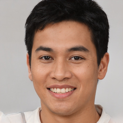 Joyful asian young-adult male with short  black hair and brown eyes