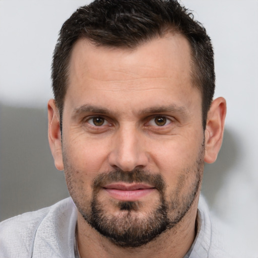 Joyful white adult male with short  brown hair and brown eyes