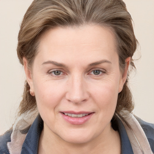 Joyful white adult female with medium  brown hair and grey eyes