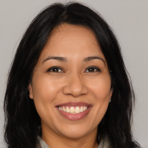 Joyful latino young-adult female with long  brown hair and brown eyes