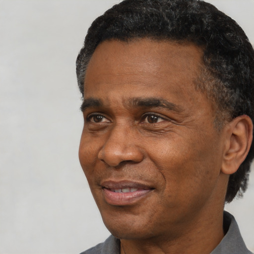 Joyful black adult male with short  black hair and brown eyes