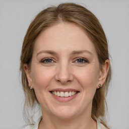 Joyful white adult female with medium  brown hair and grey eyes