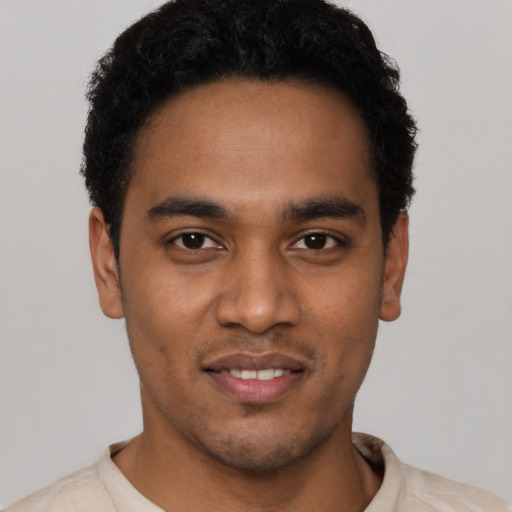 Joyful black young-adult male with short  black hair and brown eyes