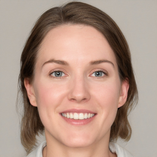 Joyful white young-adult female with medium  brown hair and blue eyes