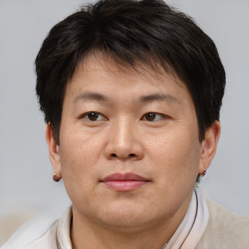 Joyful asian adult male with short  brown hair and brown eyes